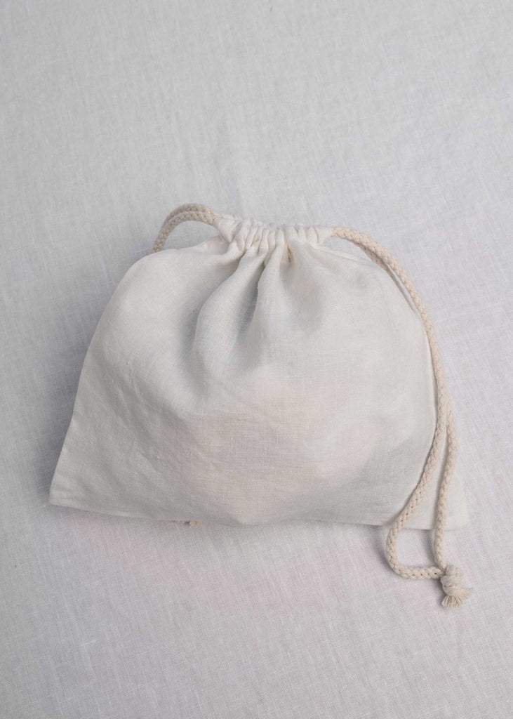 Hold all of your things in The Alma Bag. Ethically made from 100% linen and re-usable.  The perfect little travel companion to keep your luggage organized - Think make-up, undies, swimsuits, cords, scrunchies, and skincare. Or take it day to day for your snacks, produce, keys, sunglasses, or iPad. This is our Coconut Colourway.