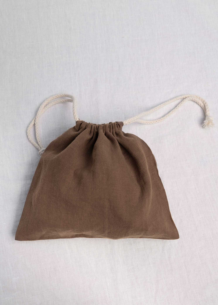 Hold all of your things in The Alma Bag. Ethically made from 100% linen and re-usable.  The perfect little travel companion to keep your luggage organized - Think make-up, undies, swimsuits, cords, scrunchies, and skincare. Or take it day to day for your snacks, produce, keys, sunglasses, or iPad. This is our Toffee Colourway.