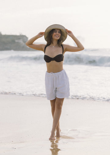 Our aussie model on the beach in her Talia Shorts in White.